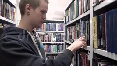 年轻的学生正在图书馆找书。 库存录像。 希普斯特学生正在图书馆找书报告